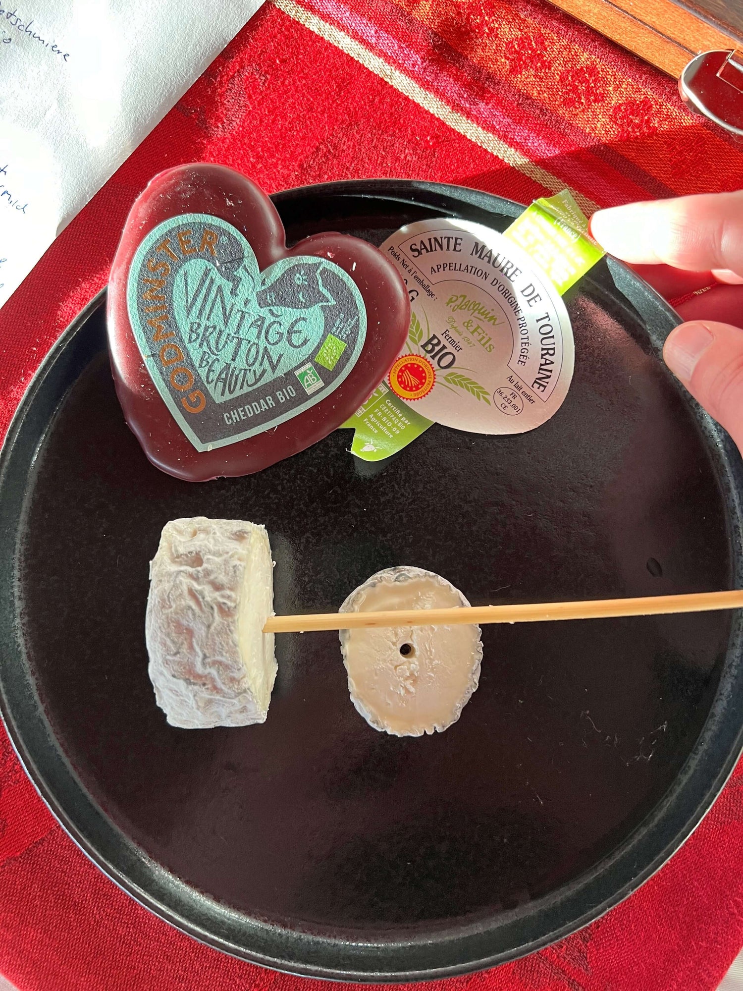 Schwarzer Teller mit verschiedenen Käsen, Vintage Cheddar und Sainte Maure de Touraine