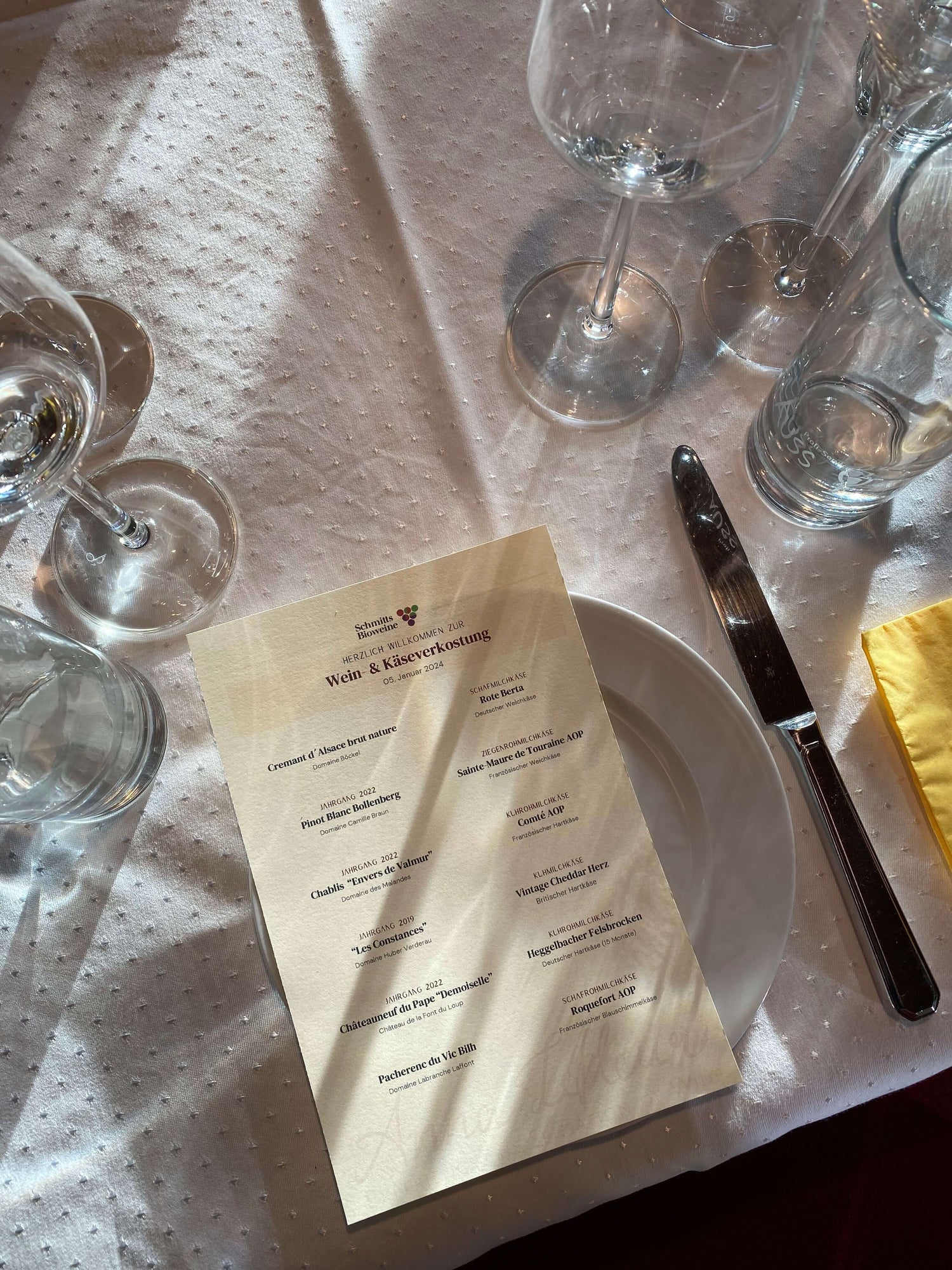 Gedeckter Tisch mit Weingläsern und einem Menü